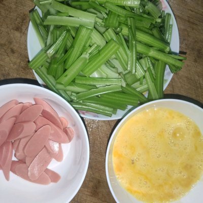 芹菜切断装盘，鹅蛋打散放碗里，火腿肠切片装碗，备用。