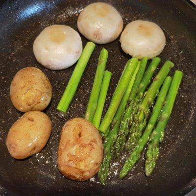 锅内放少许油煎芦笋和白蘑菇，再加入煮熟的土豆，煎至两面微黄。