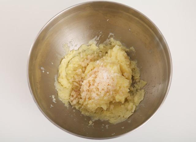 把炒好的洋葱丁倒入土豆泥碗中，搅拌均匀