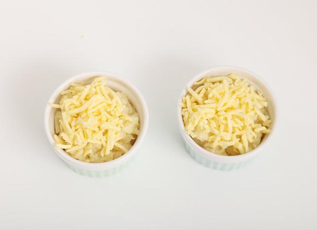 取2个空碗，把土豆泥倒入碗中，上面均匀的铺上一层奶酪