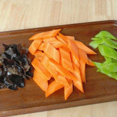 胡萝卜洗净去皮，先斜切成小段，再切成菱形片，青椒洗净去籽，切成小片，木耳提前泡发，洗净后撕成小朵